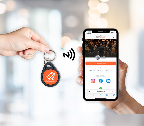 DigiVCard NFC keychain being tapped to connect with a smartphone, instantly sharing digital business card details.